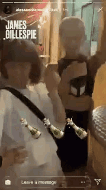 a man is holding a bottle of champagne while another man holds a bottle of champagne .