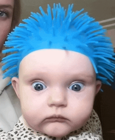 a baby wearing a blue wig with spikes on it