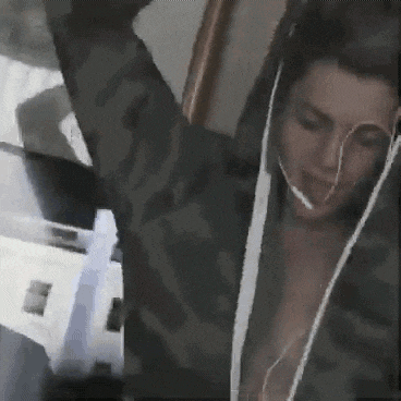 a woman is wearing headphones and a camouflage jacket