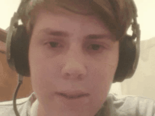 a close up of a person wearing headphones and looking at the camera .