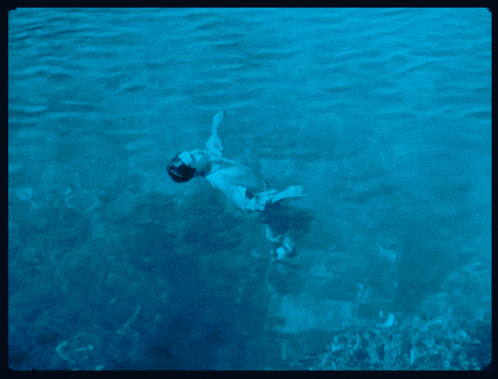 a man is floating in the water with his head above the water