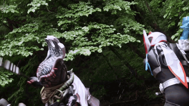 a monster with a huge mouth is standing next to another monster in a forest