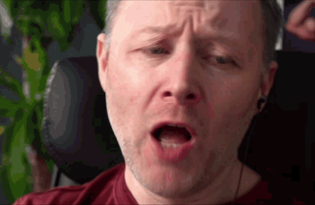a close up of a man 's face with a surprised look on his face