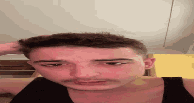 a close up of a man 's face with his hand on his head