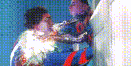 a man in a superhero costume is being attacked by another man in a superhero costume .