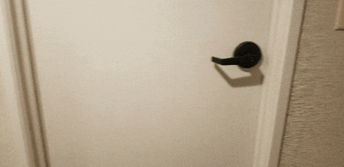 a person 's hand is pressing a button on a white wall