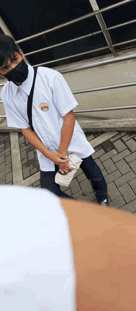 a man wearing a mask and a white shirt has a badge on his shirt that says ' a ' on it