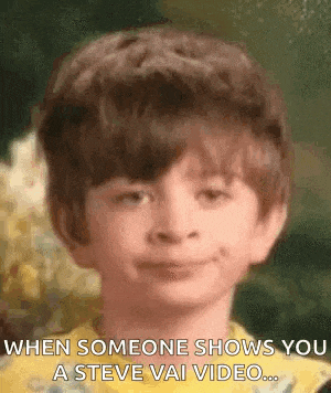 a young boy is smiling and making a funny face .