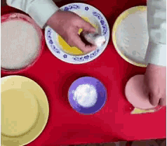 a person is preparing food on a table with plates and bowls on it