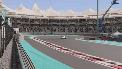 a race car is driving down a race track with a crowd in the stands