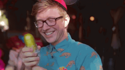 a man wearing glasses is eating a pickle in a blue shirt with bears on it