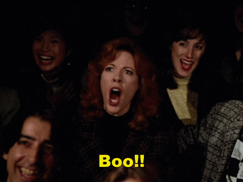 a group of people are sitting in a dark room and one of them is saying " boo "