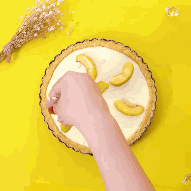 a person holding a pie with sliced peaches on top