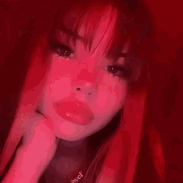 a close up of a girl 's face with red hair and red makeup .