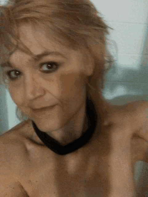 a woman without a shirt is taking a selfie