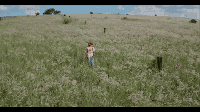a person standing in a field of tall grass