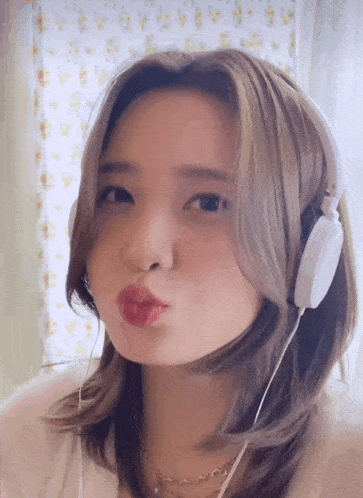 a woman wearing headphones making a funny face