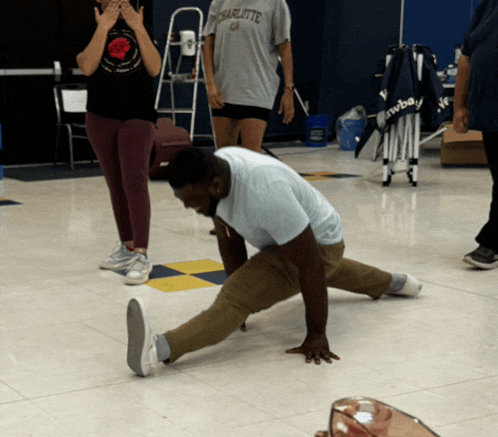 a man in a charlotte shirt is doing a split