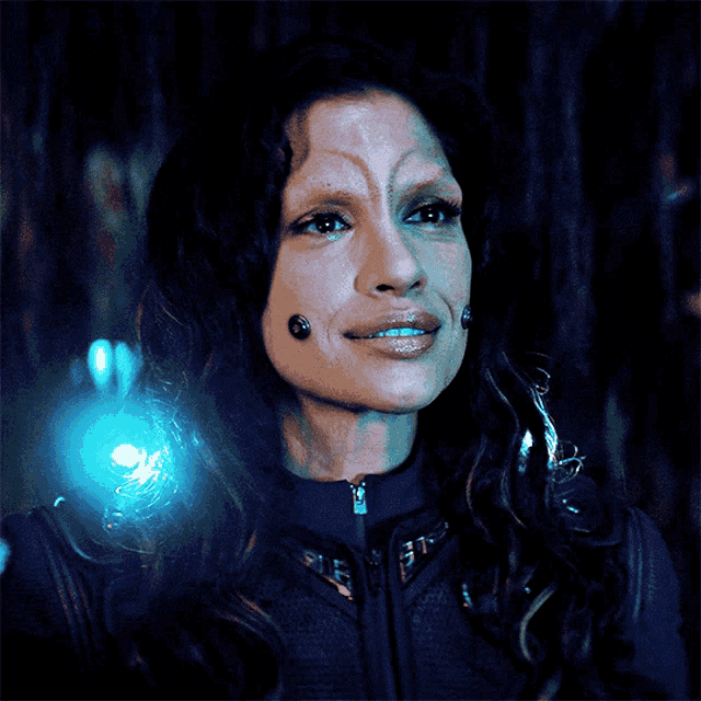 a close up of a woman 's face with a blue light shining on it