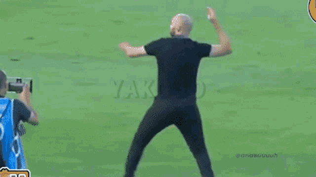 a man is running on a soccer field with the word yakobo on the bottom