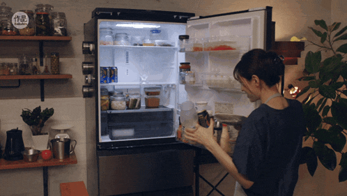 a woman stands in front of a fridge that has a sticker on it that says ' samsung ' on it