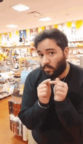 a man with a beard is making a heart with his hands in a store