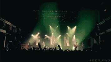 a crowd of people watching a band on stage with the letters ln on the stage