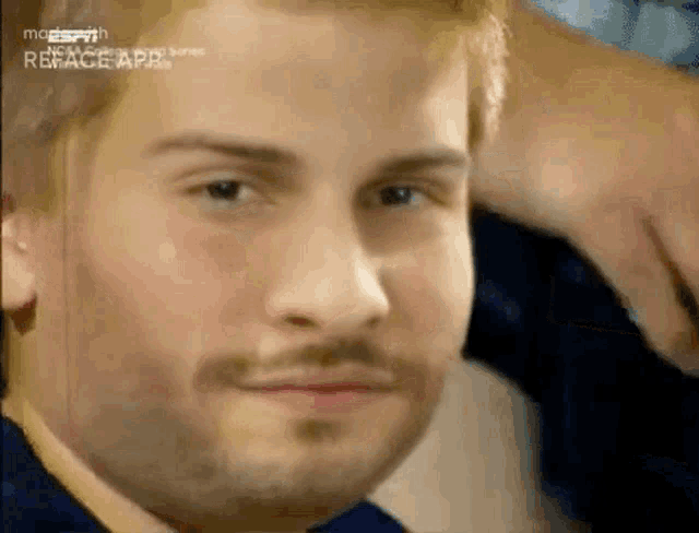 a close up of a man 's face with a beard