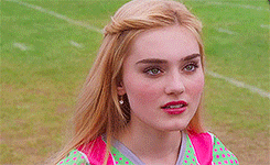 a close up of a woman 's face while standing on a football field .