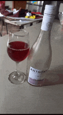 a bottle of anthony wine next to a full glass