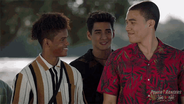 a group of young men are standing next to each other and smiling .