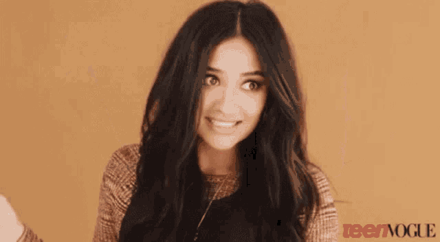 a young woman is smiling in front of a teen vogue ad