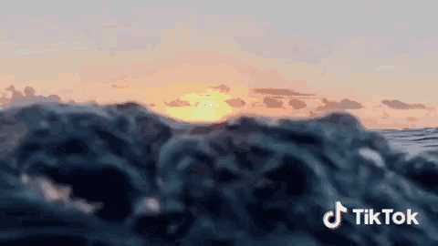 a sunset over a body of water with the tiktok logo in the corner