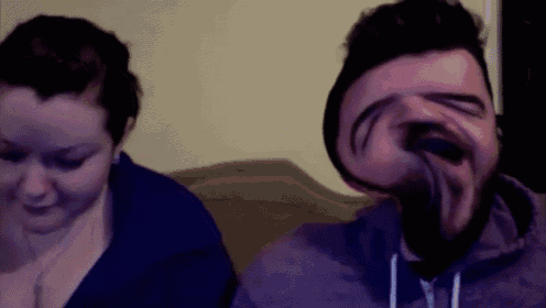 a man and a woman are sitting next to each other and the man has a strange face