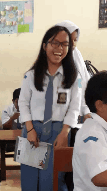 a girl wearing glasses and a tie has a sticker on her shirt that says ' a ' on it