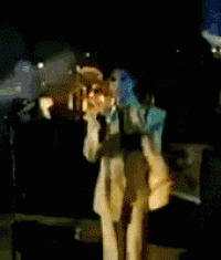 a man in a yellow suit is standing in front of a microphone