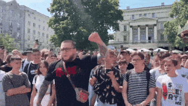 a man stands in a crowd wearing a shirt that says supreme on it