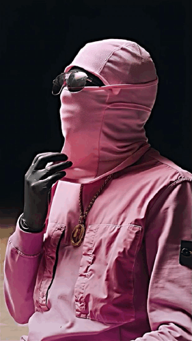 a man wearing a pink jacket with a hood on his face