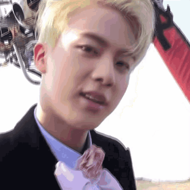 a close up of a man wearing a suit and a bow tie