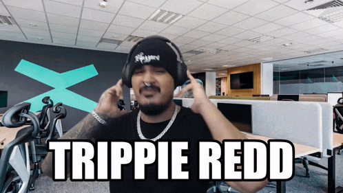 a man wearing headphones with the name trippie redd on his face