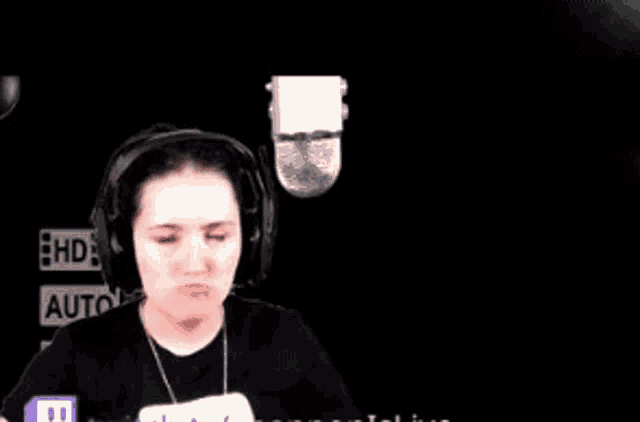 a woman wearing headphones and a microphone is making a face .