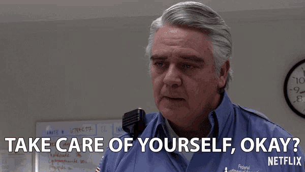 a man talking into a microphone with the words take care of yourself okay written below him