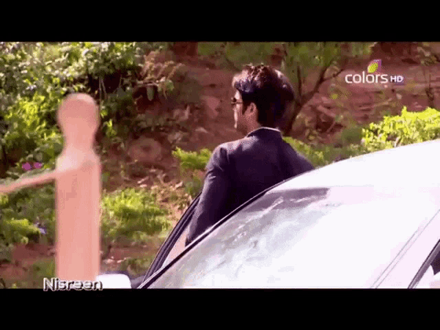 a man is getting out of a car on a colors hd screen