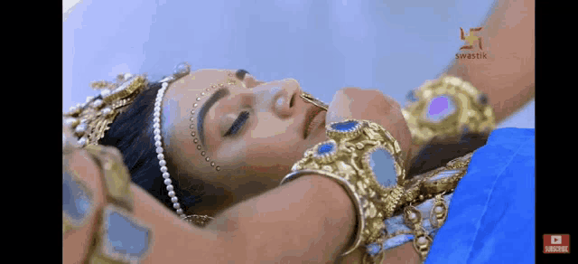 a woman in a blue and gold costume is laying down