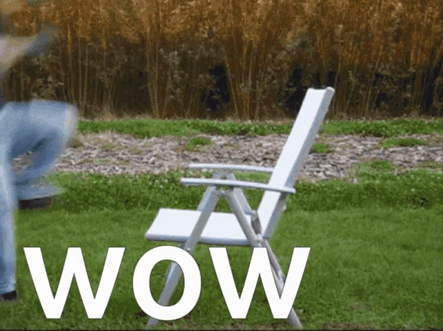 a white chair is sitting in the grass with the word wow above it