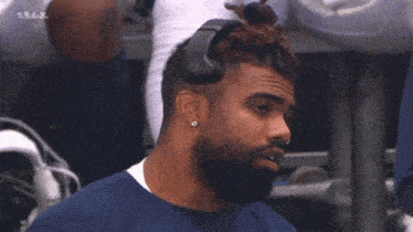a man with a beard is wearing headphones and a nose ring .