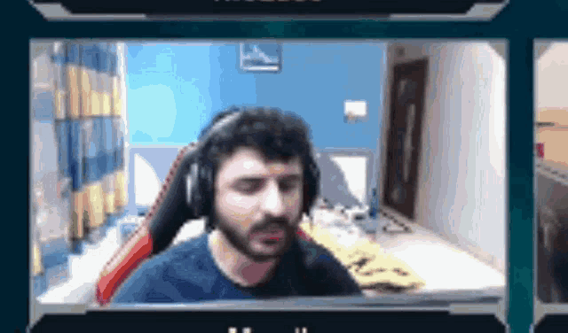 a man wearing headphones is sitting in front of a computer screen in a room .