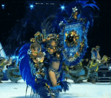 a woman in a blue feathered costume with a banner that says safrachos on it