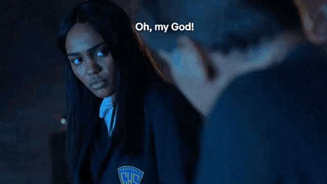 a woman in a school uniform is talking to a man in a dark room .