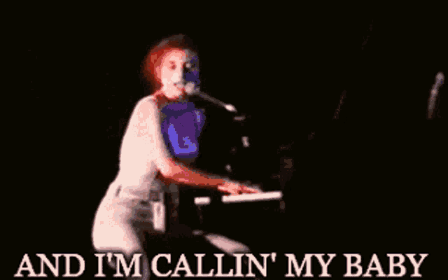 a woman singing into a microphone while playing a piano with the words and i 'm callin ' my baby below